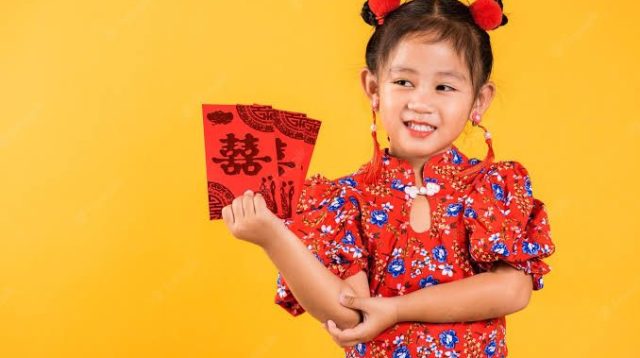 Ilustrasi anak memegang angpau (Foto: Freepik)
