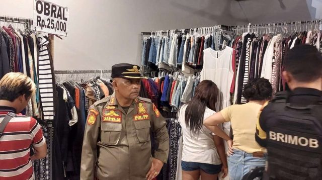 Polisi dan Satpol PP Kota Tangerang Selatan saat berada di lokasi toko obral pakaian di Serpong Utara.